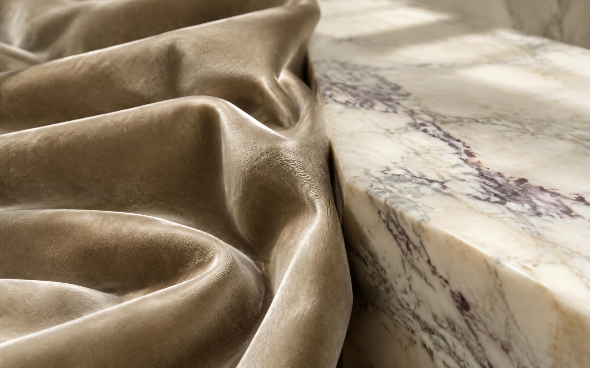 Close-up of khaki velvet and veined marble in soft natural light